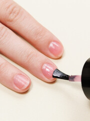 woman paints her nails with nail polish and applies nail polish with a brush. nail and hand skin care, nail service salon, manicure and pedicure.