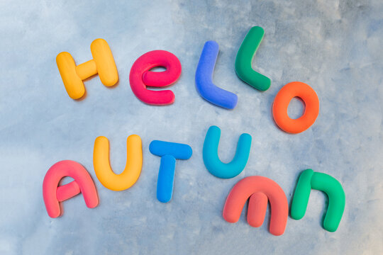 Hello Autumn message made from multi coloured clay letters on a grey background