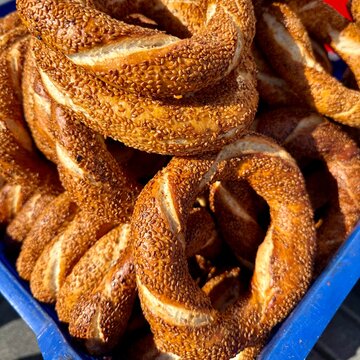 Close-up of a stack of traditional Turkish Sesame Bread Rings (Simit) in a plastic crate