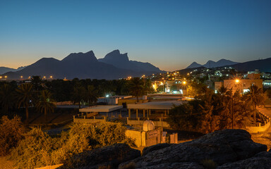 Desert village lights up at twilight