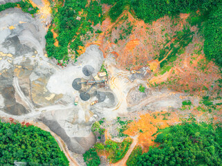 Aerial view of a quarry with heavy machinery processing stone and sand.