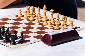 Close-up of a Chess board and timer on a table outdoors