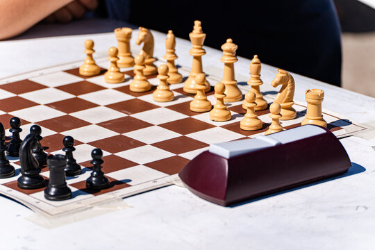 Close-up of a Chess board and timer on a table outdoors