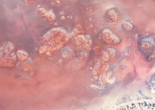 Aerial drone view of unusual rock, crystal and mineral deposit formations on the edge of a pink salt lake near Lake Tyrrell, Mallee, Victoria, Australia