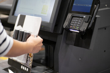 アメリカのスーパーマーケットでセルフレジを使用する女性の手元