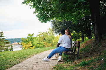Obraz premium Young couple sitting on a park bench enjoying nature