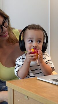 Mother and son sharing headphones and enjoying a peach