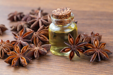 Star anise essential oil on bottle on wooden table. Alternative medicine