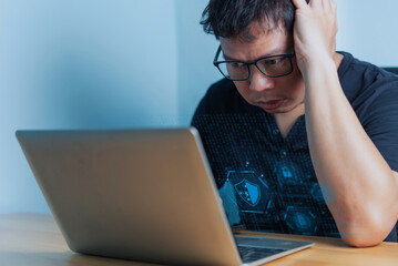 A worried man looks at his laptop screen, showing digital security icons, representing online data breach, hacking, or cybersecurity issue.