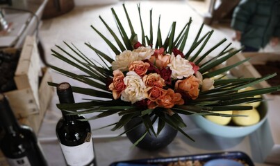 Bouquet de roses orangées et bouteille de vin