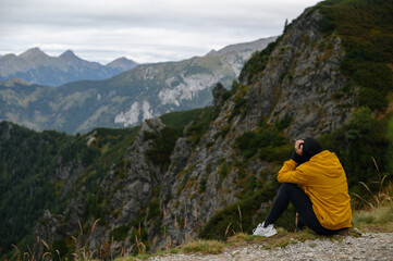 Contemplative Moment on Mountain Cliff