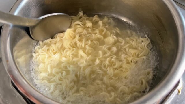 Cooking Maggi Noodles on Gas Stove | Stirring Hot Instant Noodles with Spoon in Pan