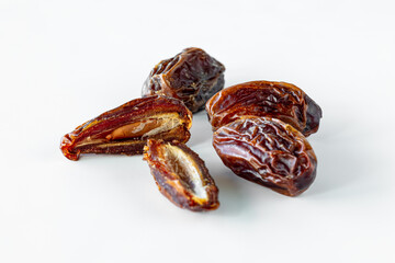 A close up of whole and cut medjool dates isolated against a white background.