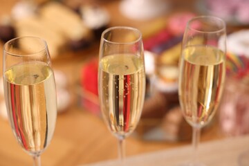 Buffet menu. Glasses of sparkling wine and desserts on table, selective focus