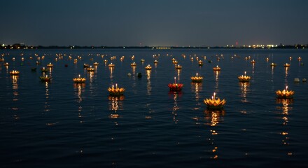 Loy krathong festival celebration with candlelit floats on water at night
