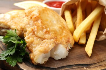 British Traditional Fish and chips on wooden board, closeup