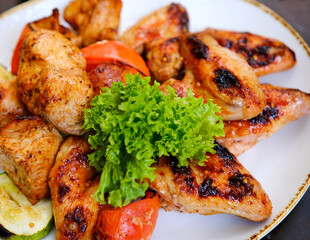Grilled chicken wings are beautifully arranged on a wooden plate, accompanied by a fresh onion salad and a small bowl of savory sauce. The meal is vibrant and appetizing, perfect .