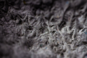 Extreme close up of old gray handmade paper clay with a structure and rough texture. Paper recycling. Selective soft focus, shallow depth of field.