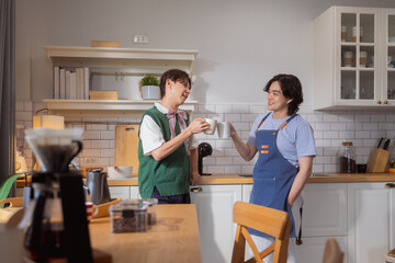Asian mature man enjoys morning coffee at cafe using drip coffee bag in beige cup on white wood table, while young adult friends relax making specialty coffee as hobby activity at home	