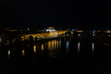 Beautiful Aerial view of Pragues National Theatre (Národní divadlo) at night with view of the city and the Vltava