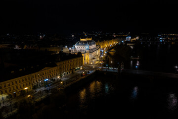 Beautiful Aerial view of Pragues National Theatre (Národní divadlo) at night with view of the city and the Vltava