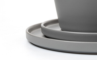 Stacked grey ceramic plates and bowl on white background