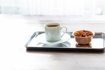 Close-Up of Traditional Turkish Coffee in a White Cup on a Metal Tray with Dried Grapes in a Copper Dish

