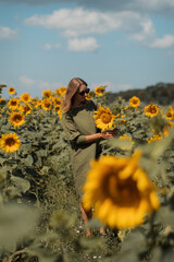 A girl in a pink skirt and a white T-shirt walks through a field of blooming yellow sunflowers. A woman dances, rejoices, smiles, enjoys life, warmth, summer, the sun. High quality FullHD footage