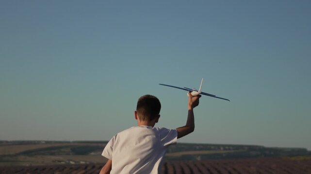 Boy airplane lavender field running through rows holding a toy glider plane dream of flight