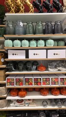 A variety of decorative plant pots, storage boxes, and woven baskets are neatly arranged on shelves in a home goods store. The pots come in different materials and colors, showcasing unique designs.