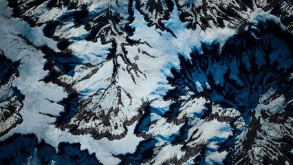 Majestic peaks covered in thick snow rise sharply from the earth, casting deep blue shadows across the rugged terrain. The serene beauty is engaging and awe inspiring, perfect for nature lovers.