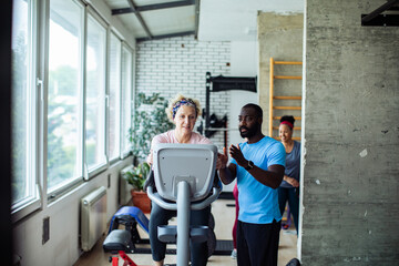 Senior woman exercising with personal trainer
