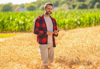 Farmer agronomist man with tablet in field. Technology of modern agriculture. Farmer man working on...