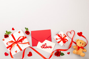 Valentine's Day composition with gifts and red roses on color background, top view