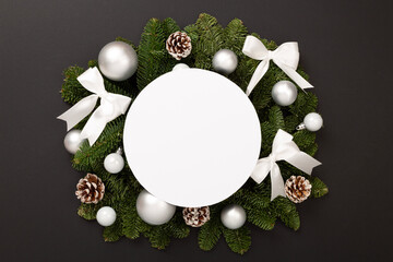 Festive Christmas tree branches with mock up black on color background, top view