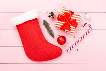 Christmas sock with gifts and decoration on wooden background, top view