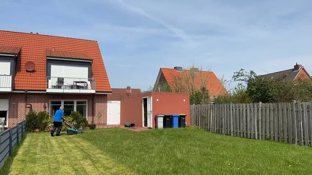 Zeitrafferaufnahme eines Mannes der einen Rasen m&auml;ht