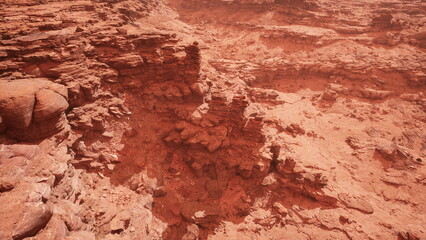 This stunning view captures a vast red landscape filled with rugged rocks and dramatic formations under a hazy atmosphere. It evokes a sense of isolation and natural beauty.