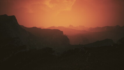 Vibrant hues fill the sky as the sun sets behind distant mountains. The serene atmosphere captures the beauty of nature, providing a moment of peace and wonder in the landscape.