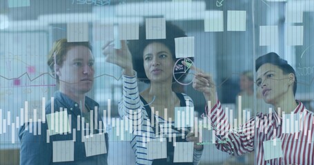 Discussing plans with three colleagues marking glass board in office, with sticky notes and charts