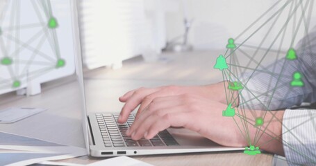 Typing male hands pressing laptop keys at office desk, displaying papers, green network icons