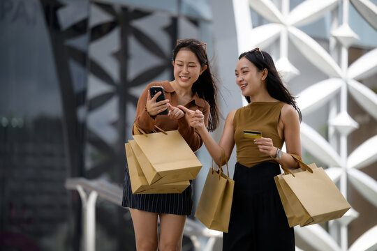 Women friends online shopping paying with credit card