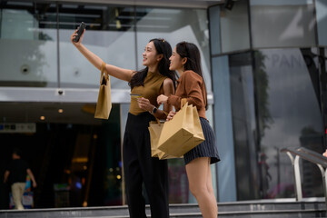 Friends shopping on city street taking selfie