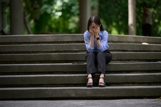 Woman experiencing stress and despair crying on stairs