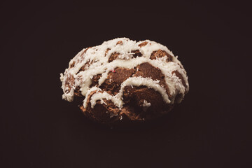 Profiteroles with coconut cream on a black background.