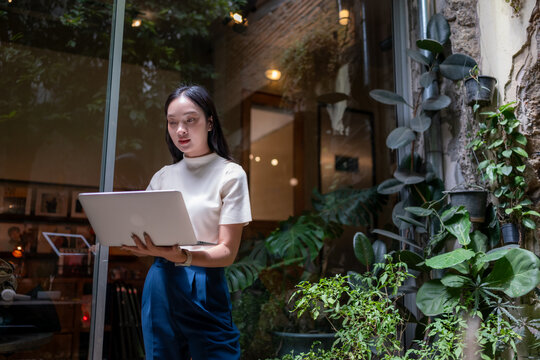 Woman working on laptop in modern green office at night
