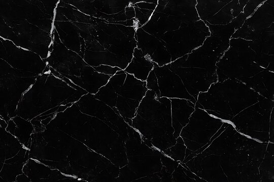 Close-up of black marble with intricate white veining, creating a natural and abstract pattern.