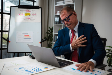 Senior businessman suffering chest pain during work