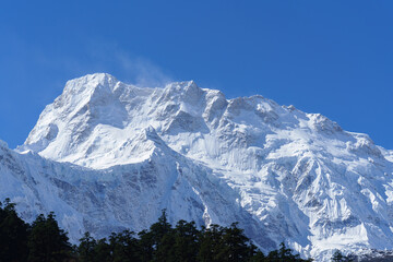 Majestic snow capped mountain peak under blue sky