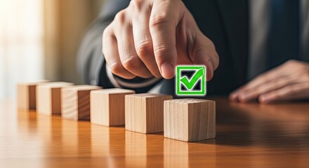 Wooden blocks lined up with hand holding a tick marked block